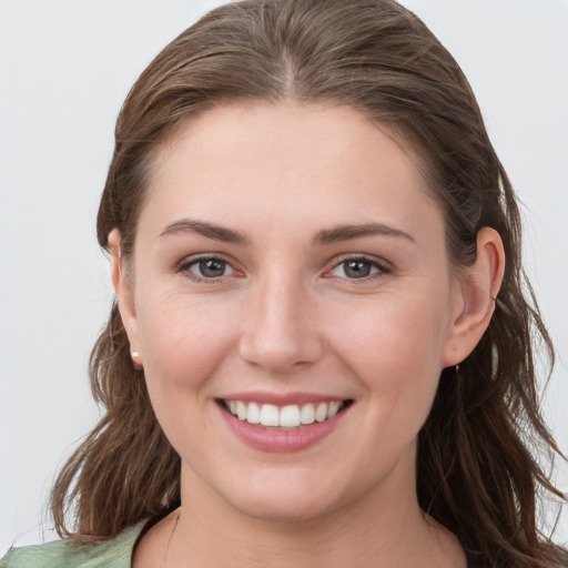 Joyful white young-adult female with long  brown hair and grey eyes