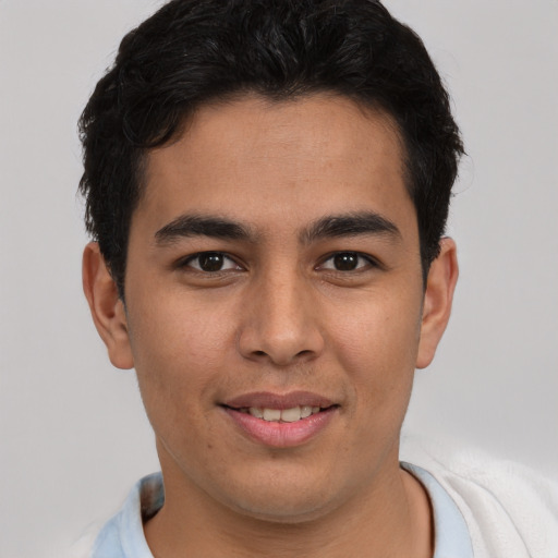 Joyful latino young-adult male with short  brown hair and brown eyes