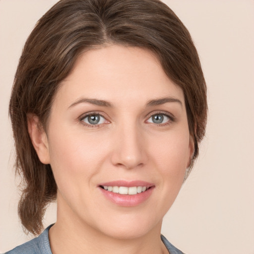 Joyful white young-adult female with medium  brown hair and grey eyes