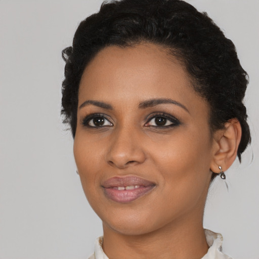 Joyful black young-adult female with short  black hair and brown eyes