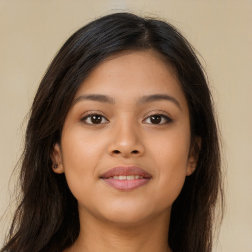 Joyful latino young-adult female with long  brown hair and brown eyes