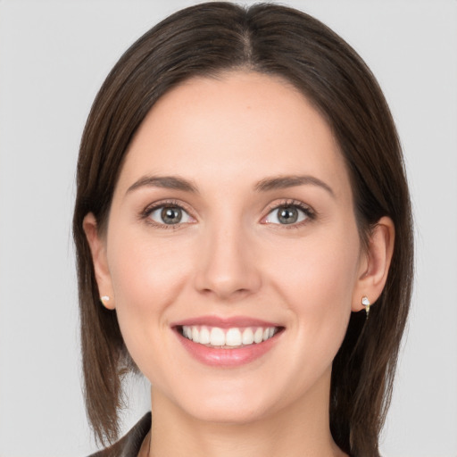 Joyful white young-adult female with medium  brown hair and grey eyes