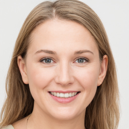 Joyful white young-adult female with long  brown hair and blue eyes