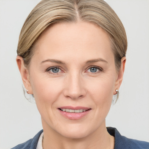 Joyful white adult female with medium  brown hair and grey eyes