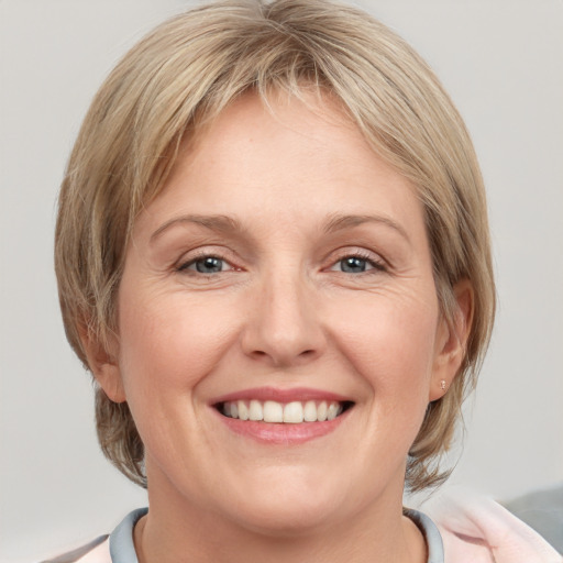 Joyful white adult female with medium  brown hair and blue eyes