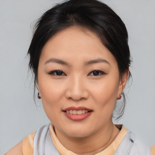 Joyful asian young-adult female with medium  black hair and brown eyes