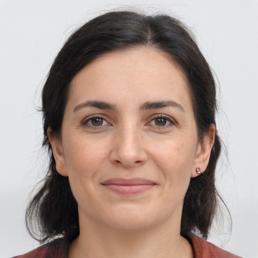 Joyful white adult female with medium  brown hair and brown eyes