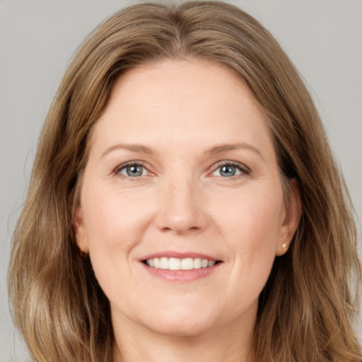 Joyful white young-adult female with long  brown hair and grey eyes