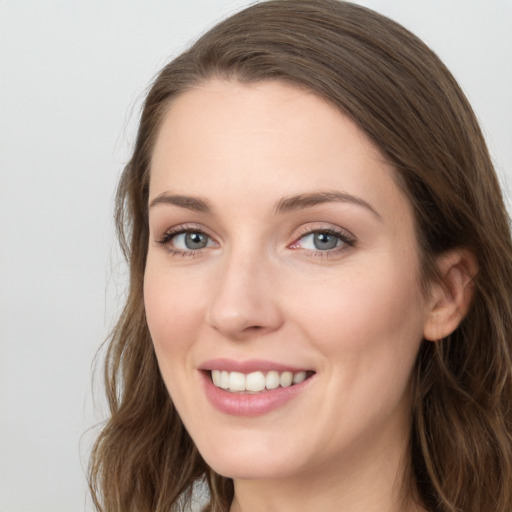 Joyful white young-adult female with long  brown hair and grey eyes