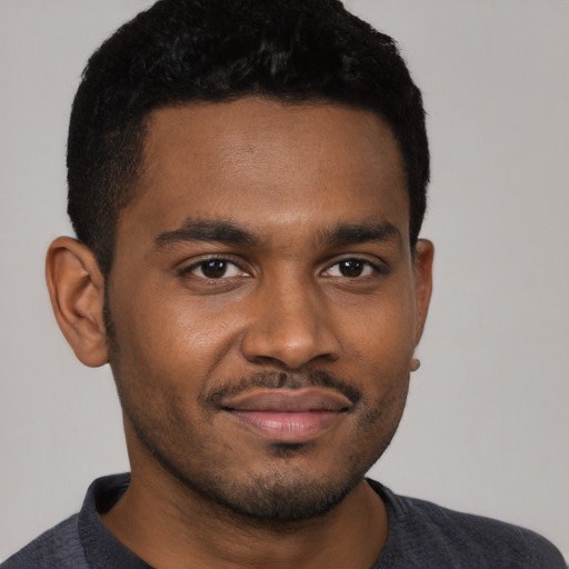 Joyful black young-adult male with short  black hair and brown eyes