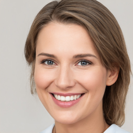 Joyful white young-adult female with medium  brown hair and grey eyes