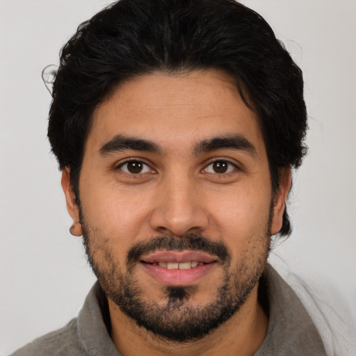 Joyful latino young-adult male with short  black hair and brown eyes