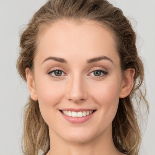 Joyful white young-adult female with long  brown hair and green eyes