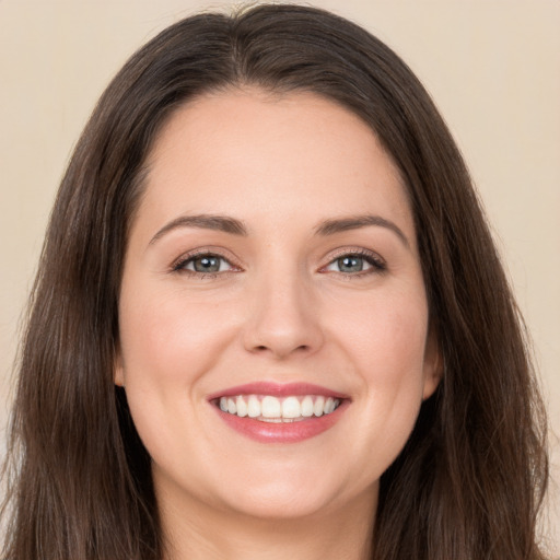 Joyful white young-adult female with long  brown hair and brown eyes