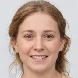 Joyful white young-adult female with medium  brown hair and grey eyes