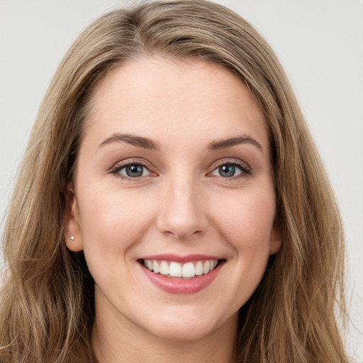 Joyful white young-adult female with long  brown hair and green eyes