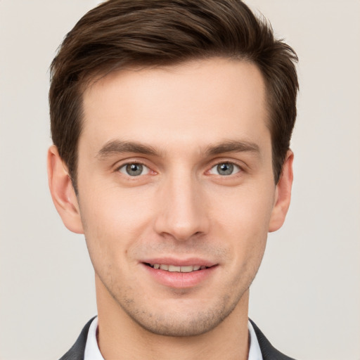 Joyful white young-adult male with short  brown hair and grey eyes