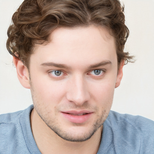 Joyful white young-adult male with short  brown hair and blue eyes