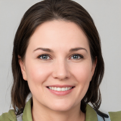 Joyful white young-adult female with medium  brown hair and grey eyes