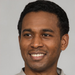 Joyful latino young-adult male with short  black hair and brown eyes