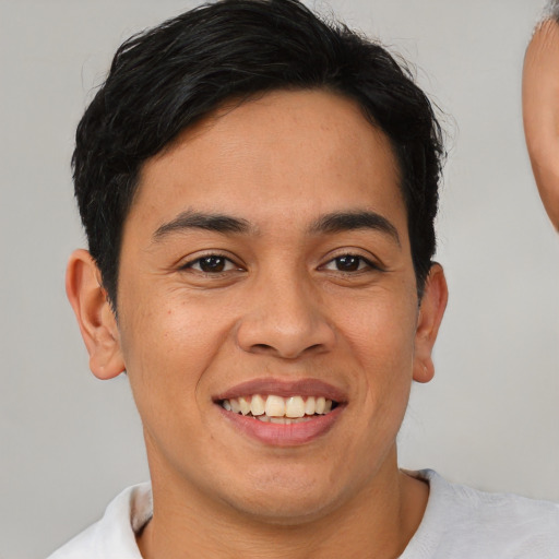 Joyful black young-adult male with short  brown hair and brown eyes