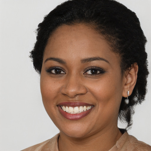 Joyful black young-adult female with long  black hair and brown eyes