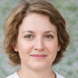 Joyful white young-adult female with medium  brown hair and green eyes