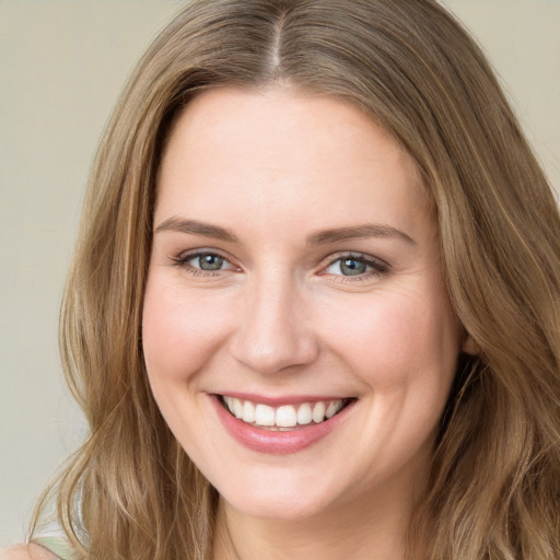 Joyful white young-adult female with long  brown hair and green eyes