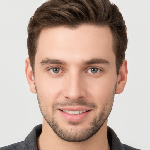 Joyful white young-adult male with short  brown hair and grey eyes