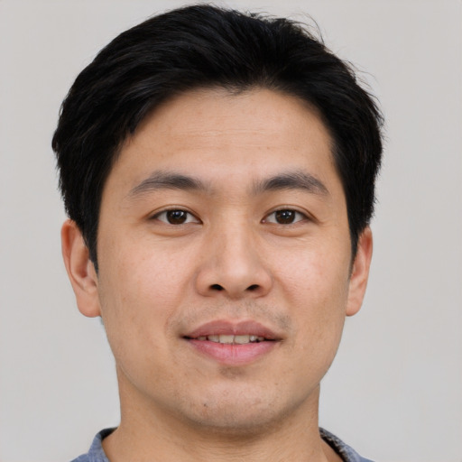 Joyful asian young-adult male with short  brown hair and brown eyes