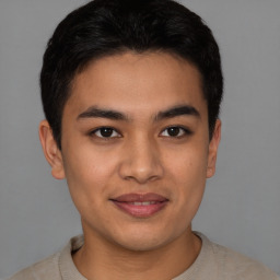 Joyful asian young-adult male with short  brown hair and brown eyes