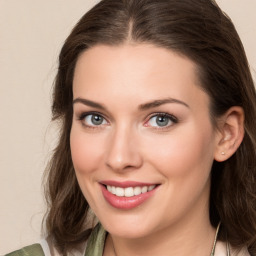 Joyful white young-adult female with medium  brown hair and green eyes