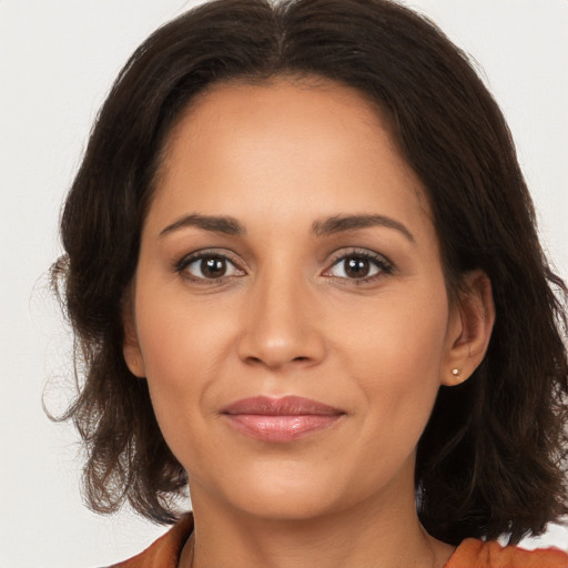 Joyful latino young-adult female with medium  brown hair and brown eyes