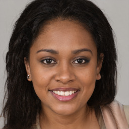 Joyful black young-adult female with long  brown hair and brown eyes