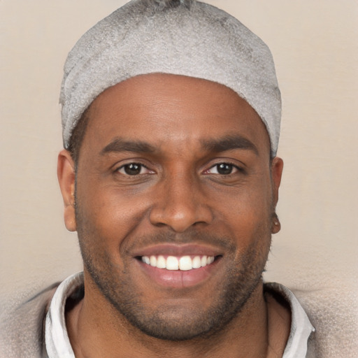 Joyful black young-adult male with short  brown hair and brown eyes