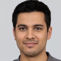 Joyful latino young-adult male with short  black hair and brown eyes