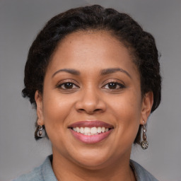 Joyful black adult female with medium  brown hair and brown eyes