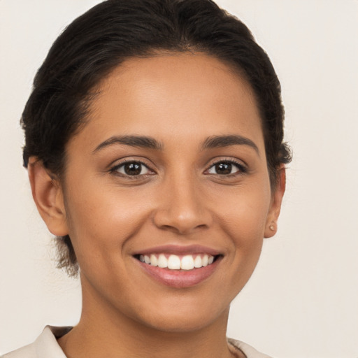 Joyful latino young-adult female with long  brown hair and brown eyes