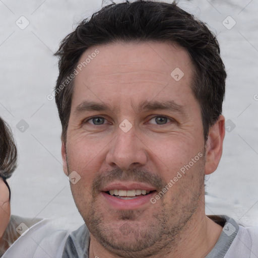 Joyful white adult male with short  brown hair and brown eyes