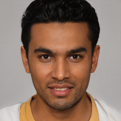 Joyful latino young-adult male with short  brown hair and brown eyes