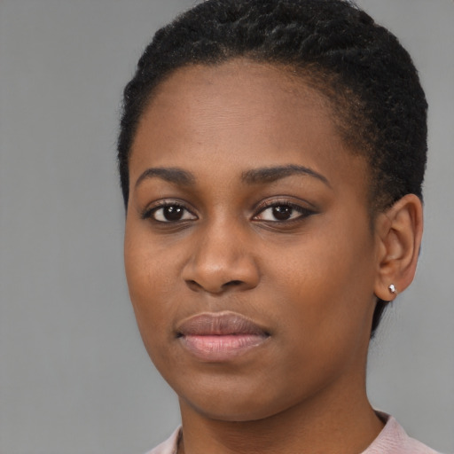 Joyful black young-adult female with short  black hair and brown eyes