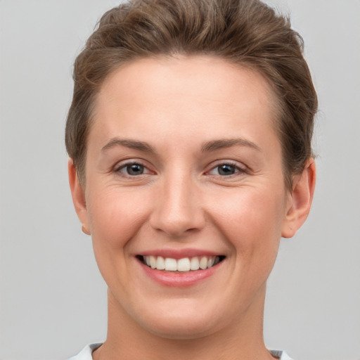 Joyful white young-adult female with short  brown hair and grey eyes