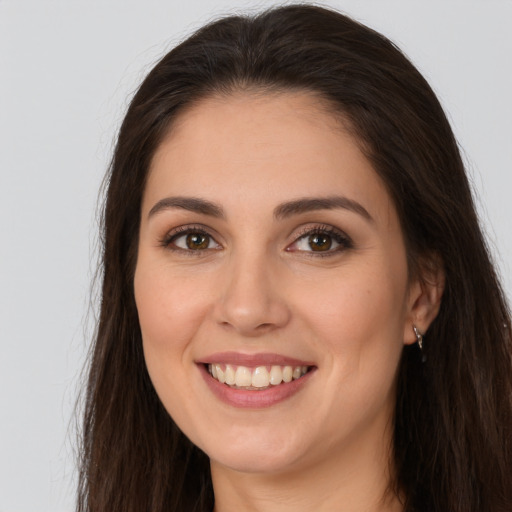 Joyful white young-adult female with long  brown hair and brown eyes