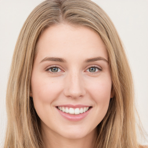 Joyful white young-adult female with long  brown hair and green eyes