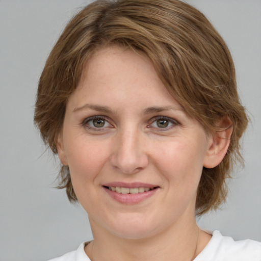 Joyful white young-adult female with medium  brown hair and green eyes