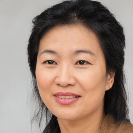 Joyful asian adult female with medium  brown hair and brown eyes