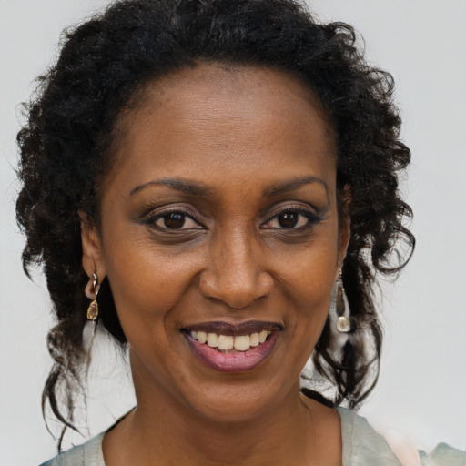 Joyful black adult female with medium  brown hair and brown eyes