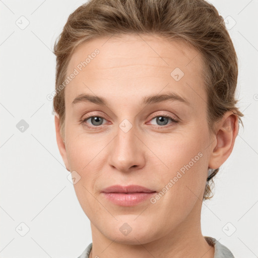 Joyful white young-adult female with short  brown hair and grey eyes