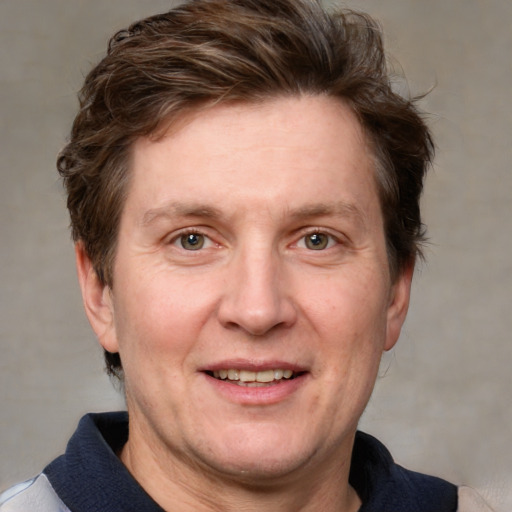 Joyful white adult male with medium  brown hair and blue eyes