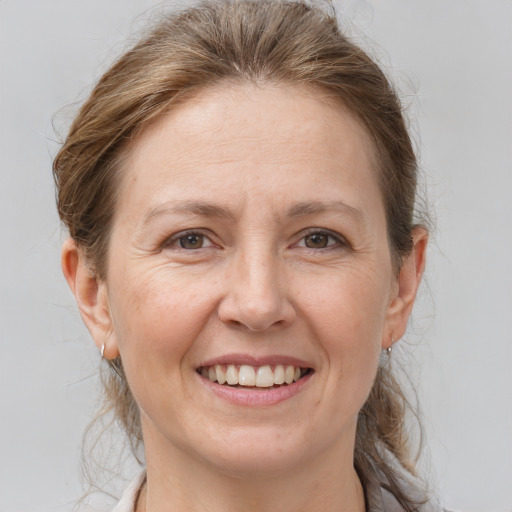 Joyful white adult female with medium  brown hair and brown eyes